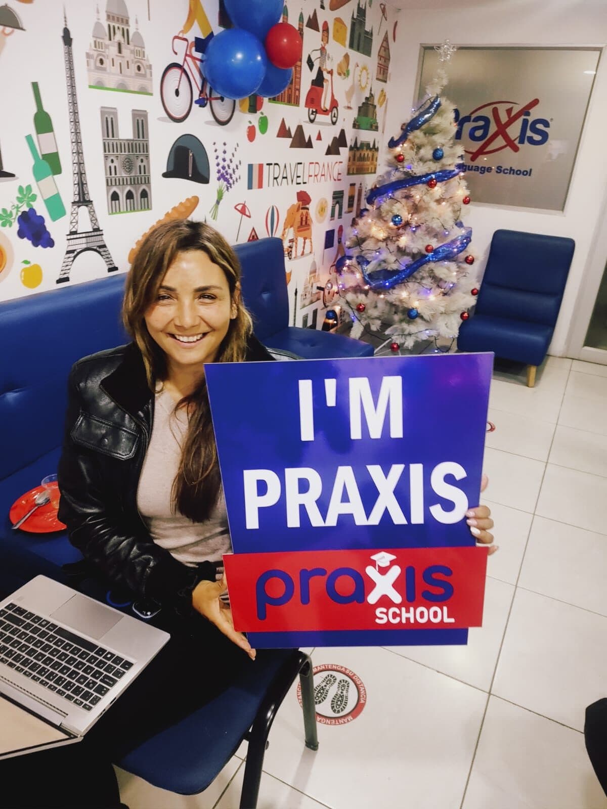 Integrante del equipo de Praxis School con el cartel I'm Praxis