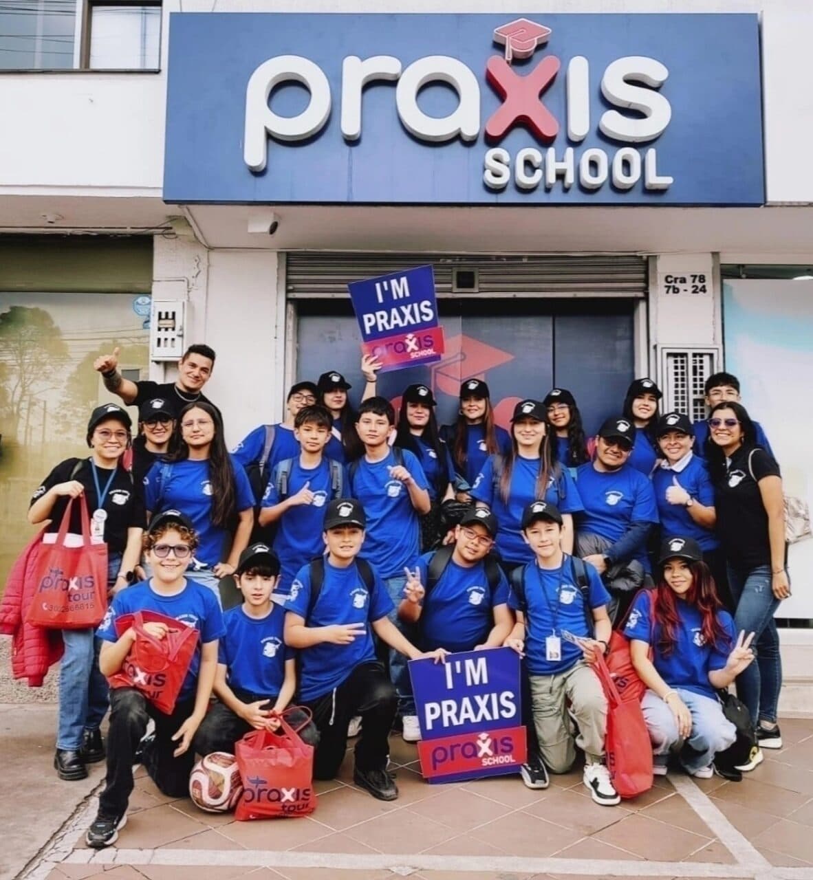 Estudiantes frente a la sede de Praxis School con la camiseta azul del Praxis Tour